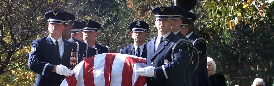 Photograph of Air Force service members carrying flag-draped coffin